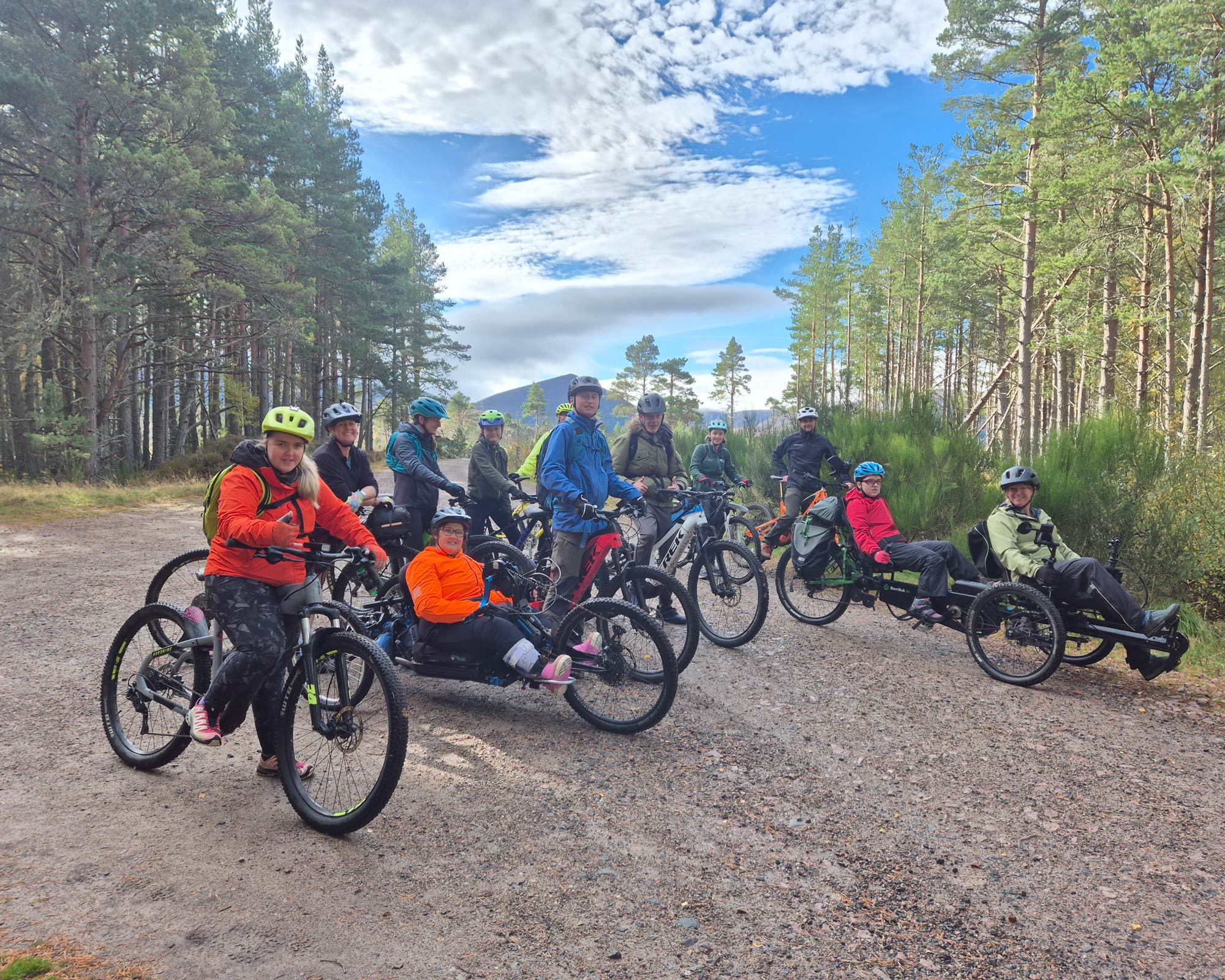 Group of adults and young people on bikes.
